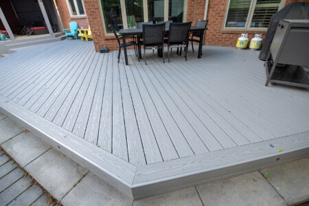 Diagonal grey composite deck boards and picture-frame border beside the outdoor dining area