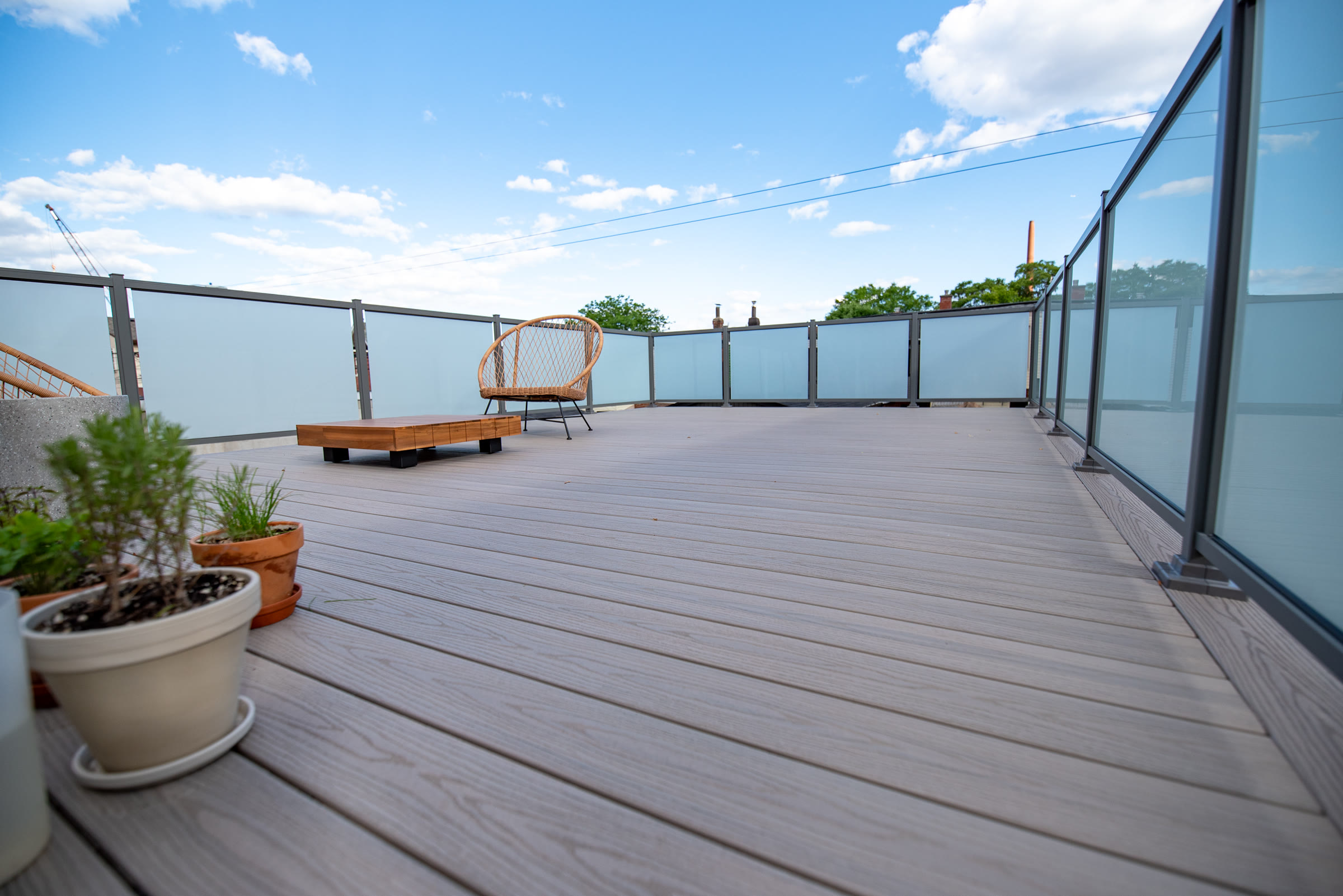 Composite rooftop deck with frosted glass privacy railings in Toronto